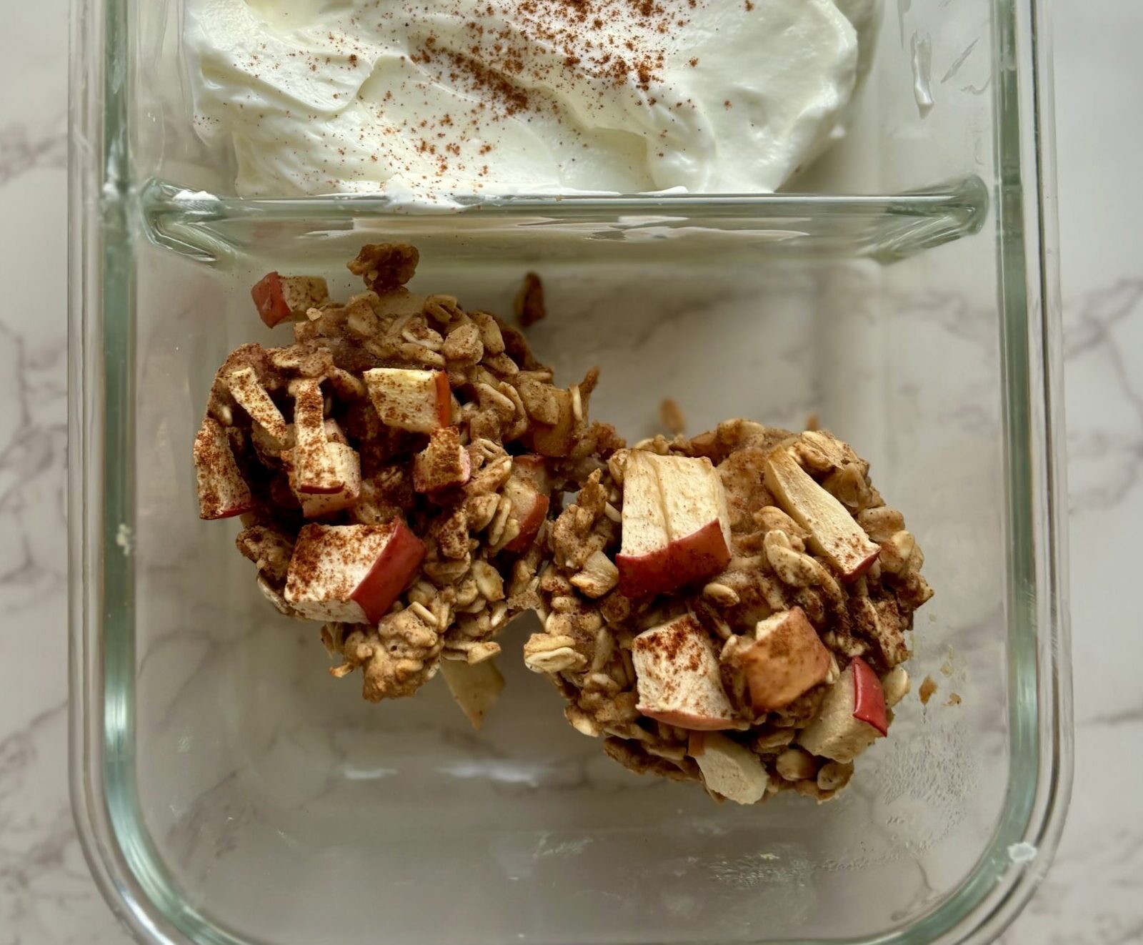 Photo of Apple Baked Oatmeal Cups in a lunchbox, paired with yogurt.